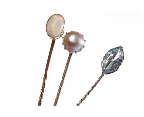 THREE EARLY TWENTIETH CENTURY PINSone set with an opal, one with a blue paste and the other with a single pearl, all unmarked