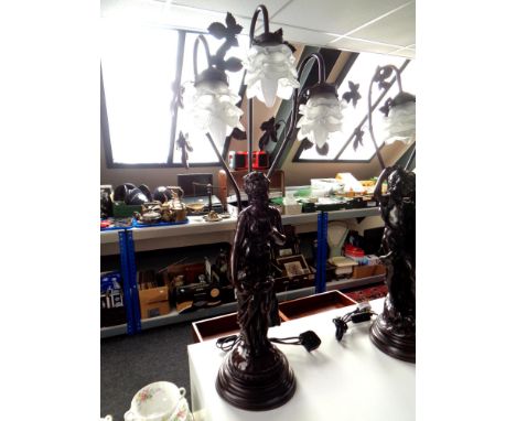 A contemporary three way figural resin table lamp, female figure with fruit basket.