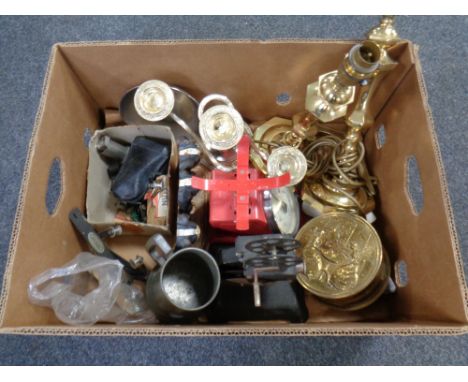 A box containing brass lamps, a table candelabra, kitchen scales, a cast iron door stop etc.