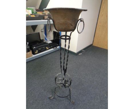 A copper planter on a wrought iron stand.
