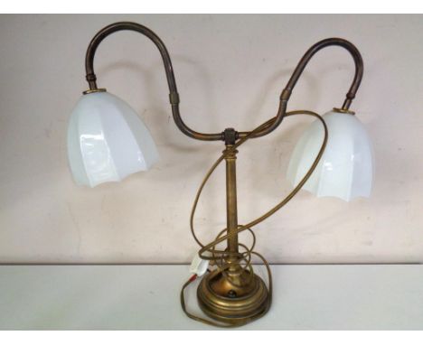 An Edwardian brass two way desk lamp with opaque glass shades.