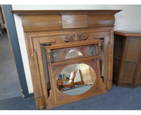 An Edwardian oak fire surround together with a similar Arts &amp; Crafts overmantel mirror with inset copper panels (2) 