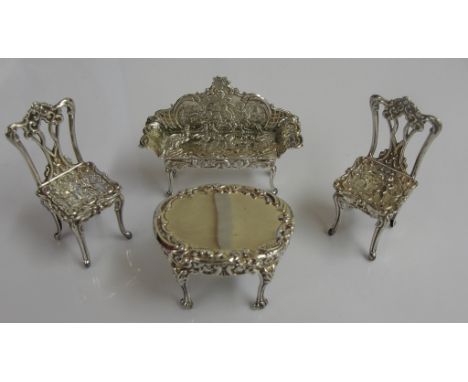 A cased set of four pieces of silver dolls house furniture: table, sofa and two chairs by David Hollander & Sons (Birmingham 