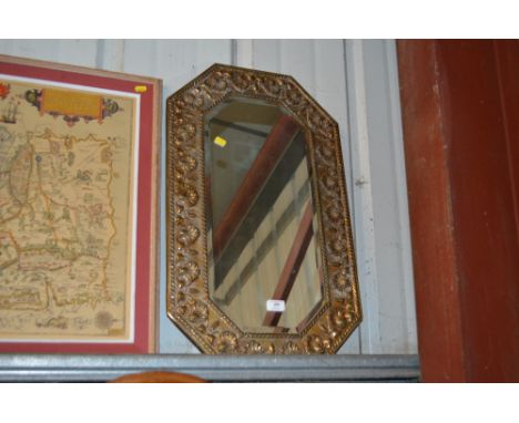 A brass embossed and bevel edged mirror