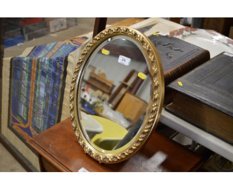 A gilt framed oval easel mirror