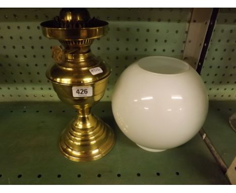 BRASS OIL LAMP WITH GLOBE SHAPED SHADE    