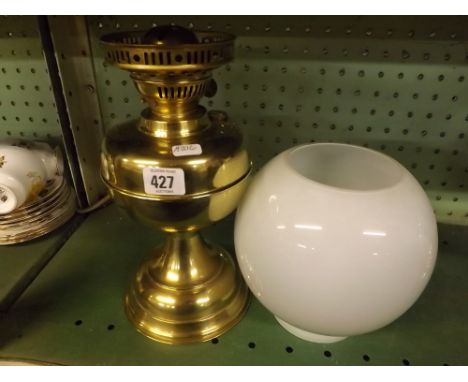 BRASS OIL LAMP WITH GLOBE SHAPED SHADE    