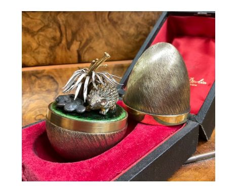Stuart Devlin (1931-2018) - an Elizabeth II silver gilt surprise Easter egg, enclosing a Hedgehog and leaves, on enamelled ba