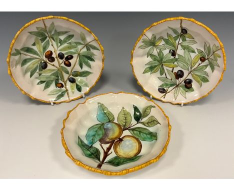 A set of three Cantagalli maiolica shaped circular dishes, each painted with fruiting branches, 16cm diam, cockerel mark, c.1