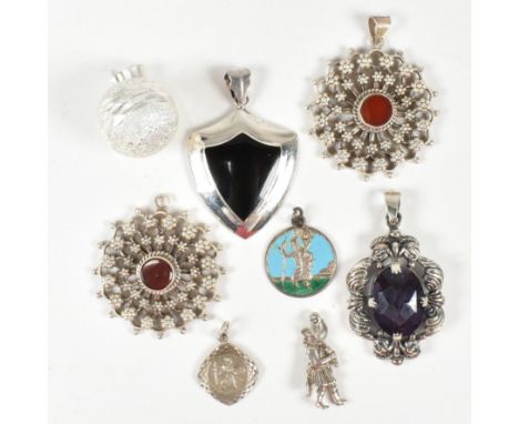 A collection of silver and gem set necklace pendants. The necklace pendants to include two metal beadwork and red stone set p