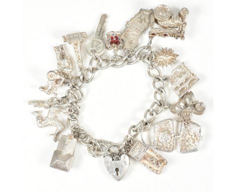 A hallmarked silver curb chain strung with 15 charms to hallmarked silver heart padlock clasp. The charms to include a train,
