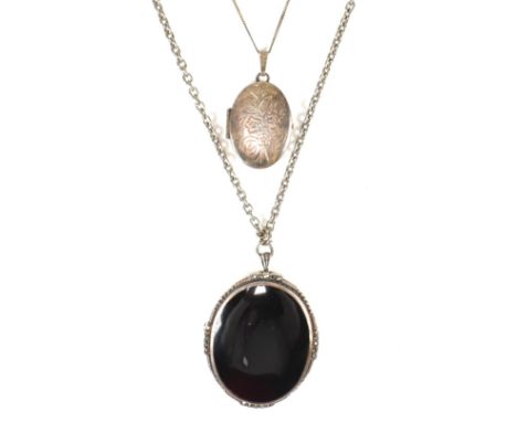 Two silver pendant necklaces. The necklaces to include a silver, black enamel and marcasite oval pendant with brooch hinge pi