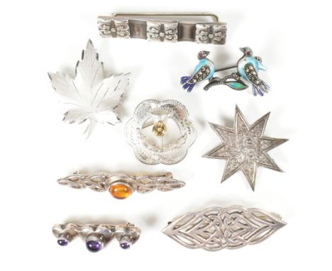 A collection of silver and gem set brooch pins. The brooches to include gem set brooches, thistle brooch, enamel birds, maple