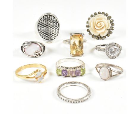 A collection of silver and gem set rings. The rings to include white stones, carved flower, marcasite, Suffragette coloured s