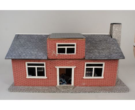 A vintage childs dolls house with furniture and dolls
