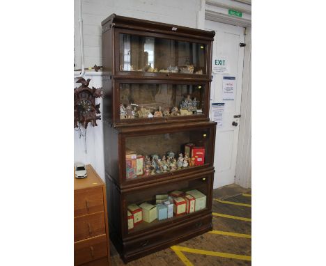A Globe-Wernicke type stacking bookcase, the four graduated and stepped shelves with glazed fall fronts, over a base drawer, 