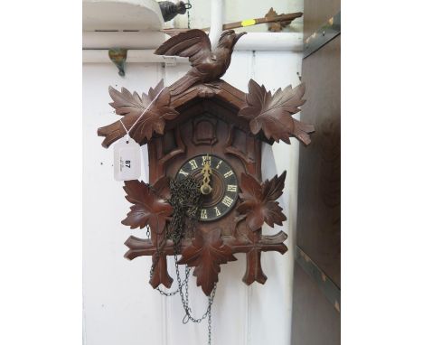 A carved softwood Swiss cuckoo clock, the twin train movement with bellows and coil gong, retail label for T.H. Anderegg Fils