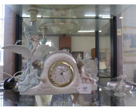 A Lladro table lamp, with a child sitting on an outstretched dove, 33 cm high, a Lladro table clock, Lladro Society display, 