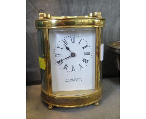 An oval brass carriage timepiece clock, inscribed Alfred Taylor Tunbridge Wells, with enamelled dial, bevelled glass and sing