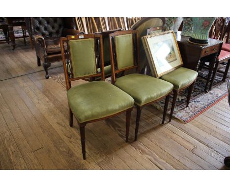 A set of four Edwardian mahogany and satinwood crossbanded dining chairs, the rectangular upholstered backs with lattice desi