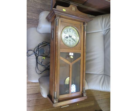 A 1930s wall clock, with silvered dial and glazed door enclosing a three train movement striking on gongs, 94 cm high 