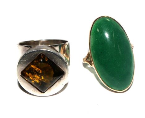 A 9 carat gold ring set with a large green stone together with a silver and an amber ring 