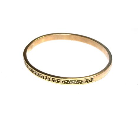 A 14 carat gold bangle with key pattern decoration 