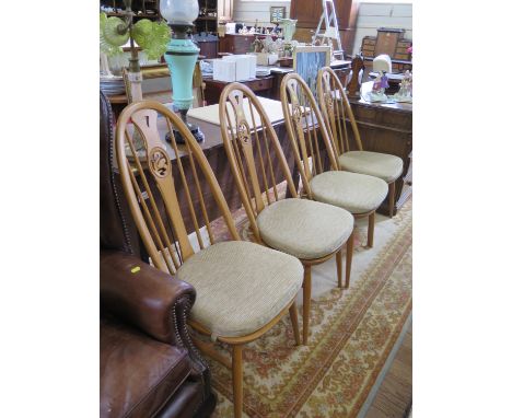 A set of four Ercol ash Windsor type dining chairs, the splats with pierced carving of swans (4) 