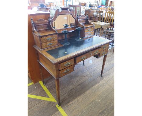 An Edwardian inlaid rosewood writing desk, the raised mirrored back with trinket drawers, over a leather inset top and five d