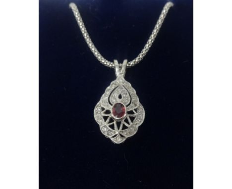 An 18ct ruby and diamond white gold pendant and chain.