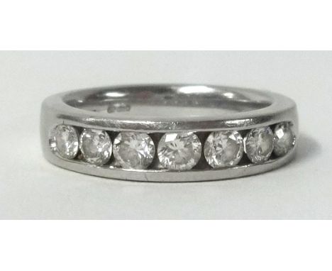 A platinum half band diamond eternity ring, set with 7 round cut diamonds.