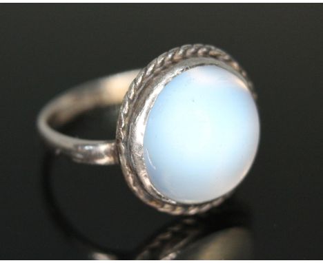 An antique moonstone cabochon ring, the bezel set flat bottom and round cut cabochon weighing approx. 6.74ct, rope twist bord