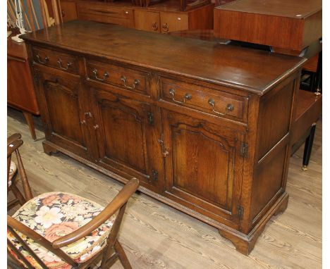 A reproduction aged oak sideboard, length 169cm, depth 46cm & height 89cm. Condition- some light general wear to include surf