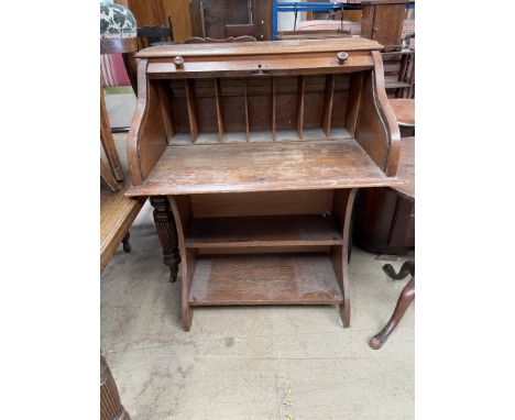 An early 20th century oak desk, with a tambour front, enclosing a fitted interior above a shelf 