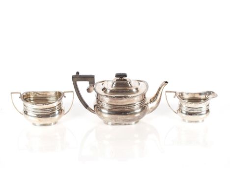 An Edwardian&nbsp;three piece silver tea set,&nbsp;with reeded decoration, the teapot with black wood handle and lift, Sheffi