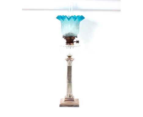 A Corinthian&nbsp;column plated oil lamp,&nbsp;having clear glass dimpled reservoir and blue tinted and engraved tulip shade,