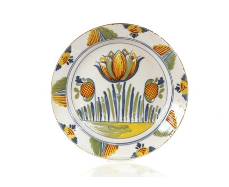 A fine 18th Century English Delftware tulip&nbsp;charger,&nbsp;painted in blue green, red and yellow with a central stylised 