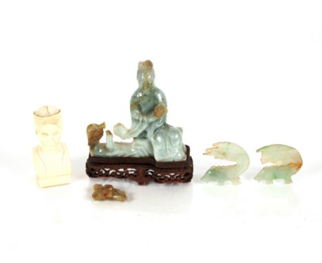 A jade figure of a seated woman,&nbsp;on carved hardwood stand AF; a carved ivory bust; and two jade fish ornaments (4)