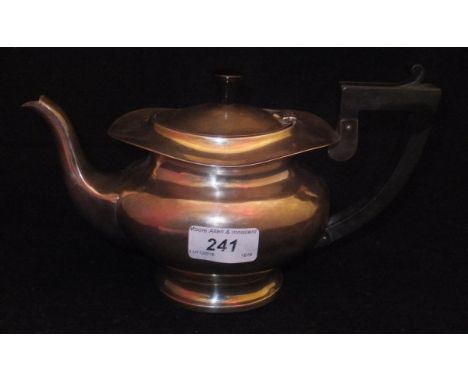 A George V silver teapot of oval baluster form, raised on an oval foot with ebonised handle and finial (by Robert Chandler, B