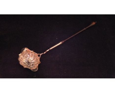 A 19th Century white metal punch ladle with turned wooden handle, the bowl with embossed floral decoration