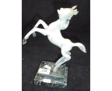 A 20th Century Istvan Komaromy lamp work figure of a rearing horse in opalescent white glass  raised upon a stepped green mar