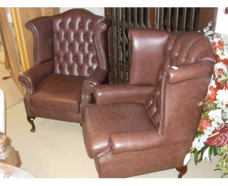 A pair of modern brown leather button back wing arm chairs on mahogany cabriole legs