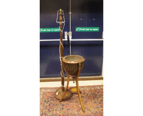 A 19th Century mahogany plant stand with brass liner, lion mask handles, raised on three legs united by a shaped undertier to