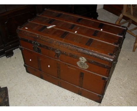 A brown painted steamer trunk with iron bindings