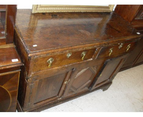 A 19th Century oak dresser, the plain top above two short drawers with brass drop handles above two cupboard doors raised on 