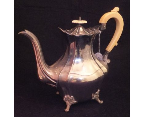 A Victorian silver teapot of lozenge shaped form, raised on four ball feet set with ivory handle and finial (by Goldsmiths & 