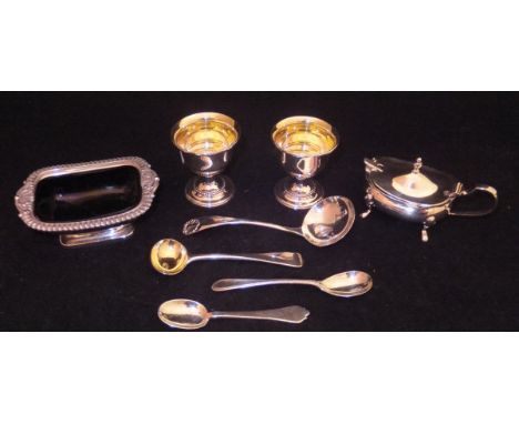 A collection of silver wares comprising a silver salt with blue glass liner, a pair of matching egg cups, a silver mustard sp