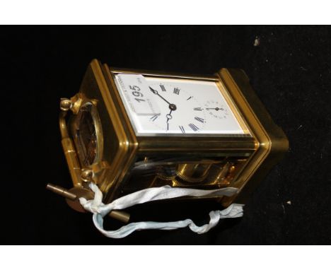 A brass and glass carriage clock with Roman numerals to the enamelled dial with subsidiary hours dial and alarm