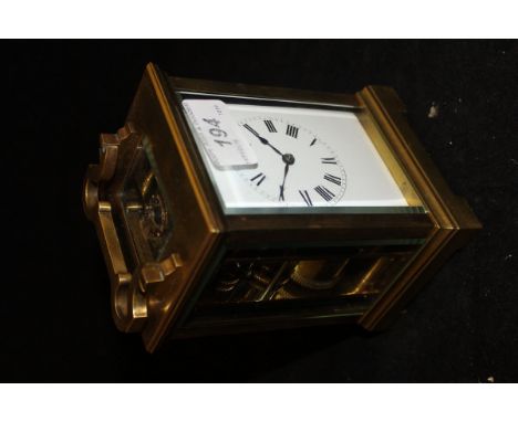A brass and glass carriage clock with Roman numerals to the enamelled dial