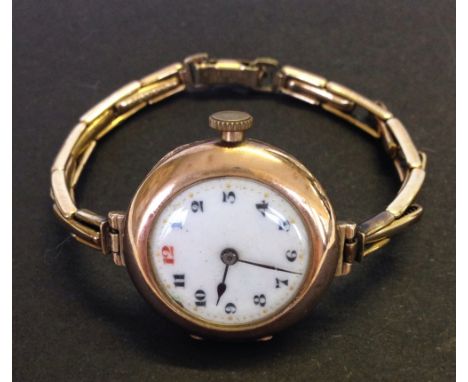 Ladies vintage Rolex 9ct gold cased watch with rolled gold strap. Dial with red enamelled number 12.  In good working order.
